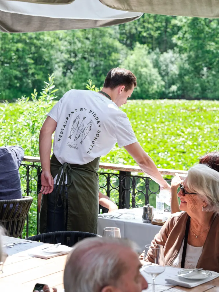 Bediening op het terras in een shirt van Restaurant by Sidney Schutte